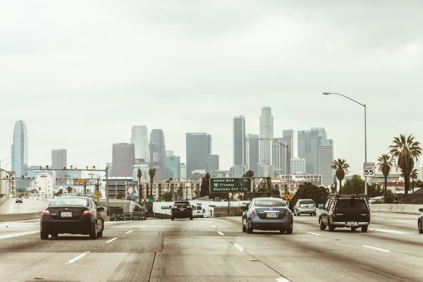 a busy highway with lots of cars travelling into the city 